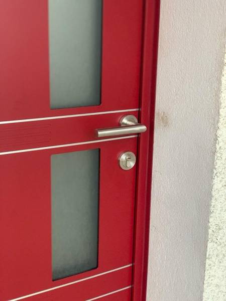 Détail porte d'entrée rouge contemporaine avec vitrage dépoli
